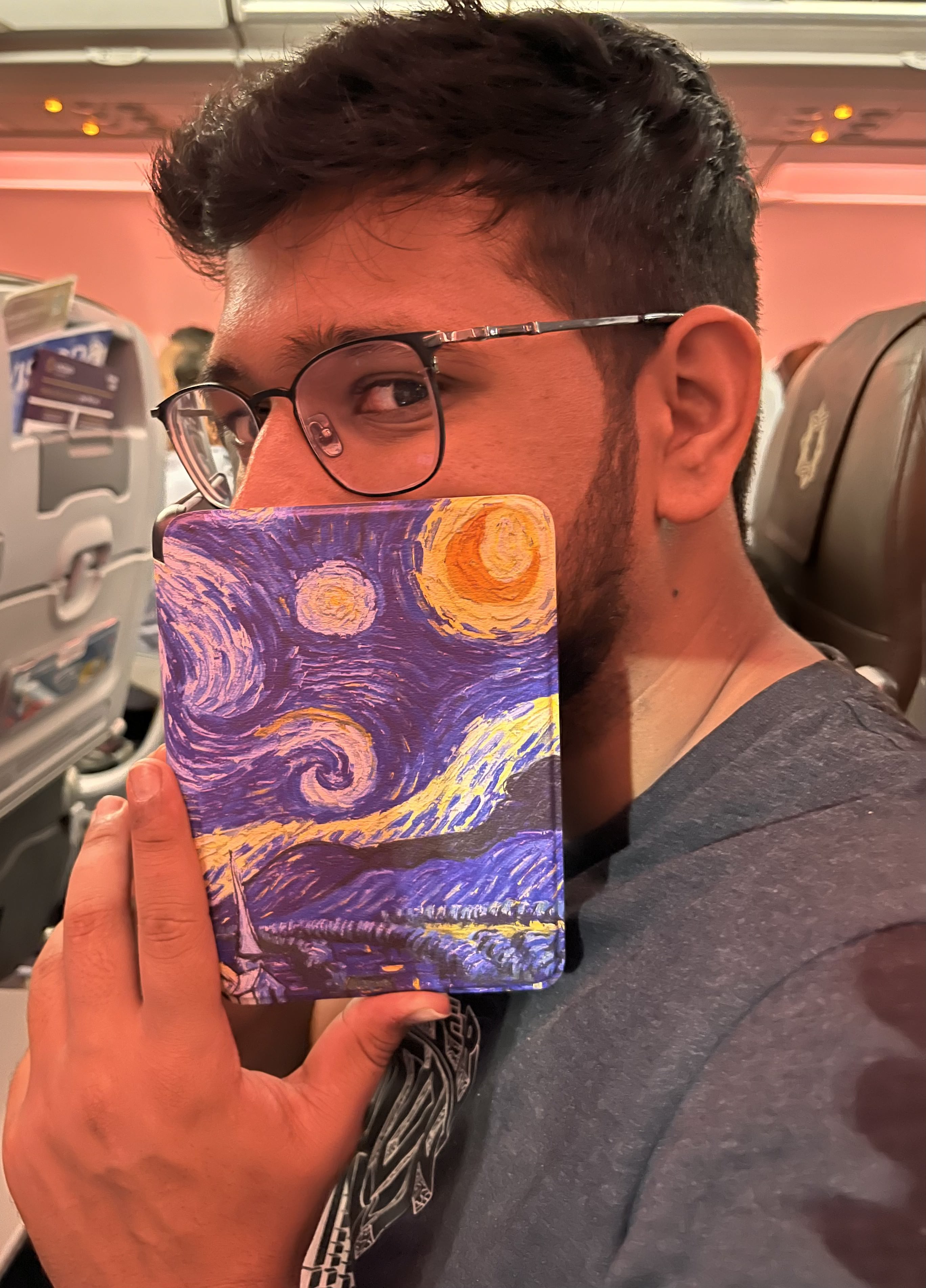Shubhashish Dixit smiling in a red plaid shirt and tortoise shell glasses